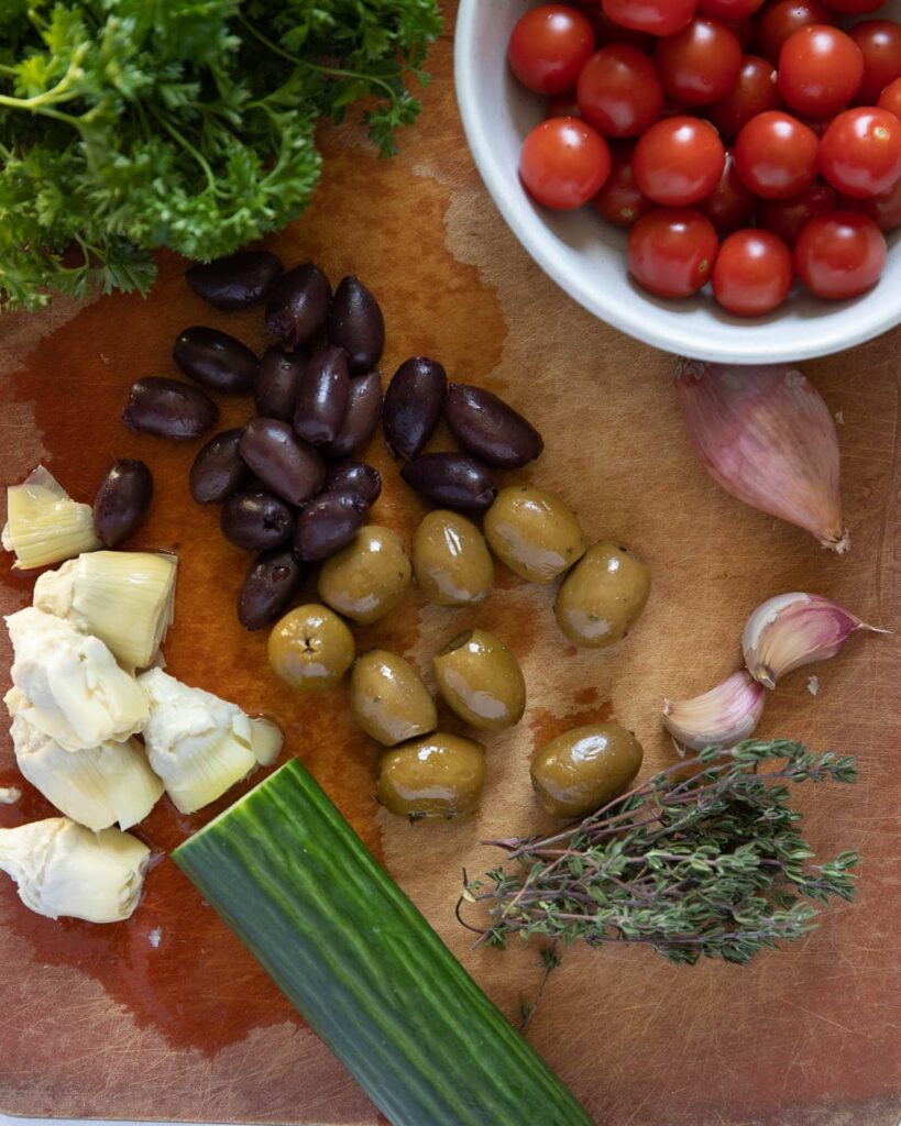 Mediterranean and Brown Rice salad, some of the ingredients; cherry tomatoes, parsley, olives, artichoke hearts, garlic, shallot, cucumber, thyme
